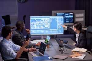 Board members in a meeting room reviewing cyber governance and risk data on a large digital display. NIS2 board governance.
