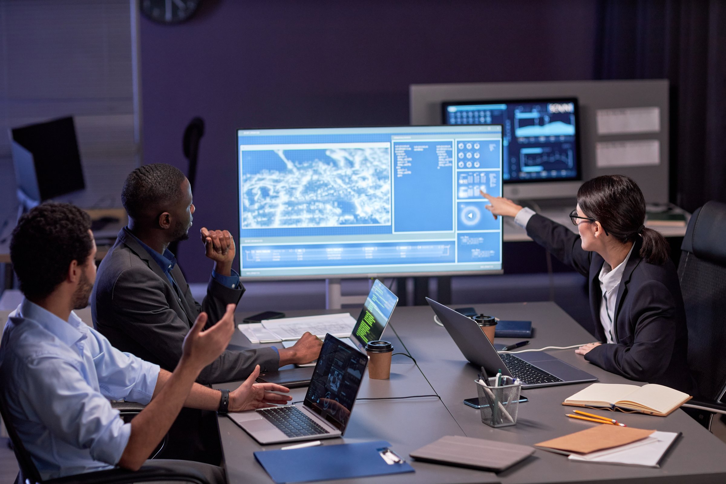 Board members in a meeting room reviewing cyber governance and risk data on a large digital display. NIS2 board governance.